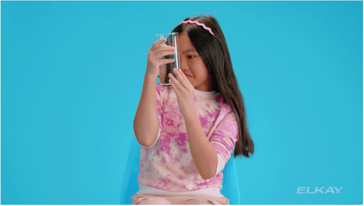 img-lifestyle_dark-haired-girl-looking-at-glass-of-water